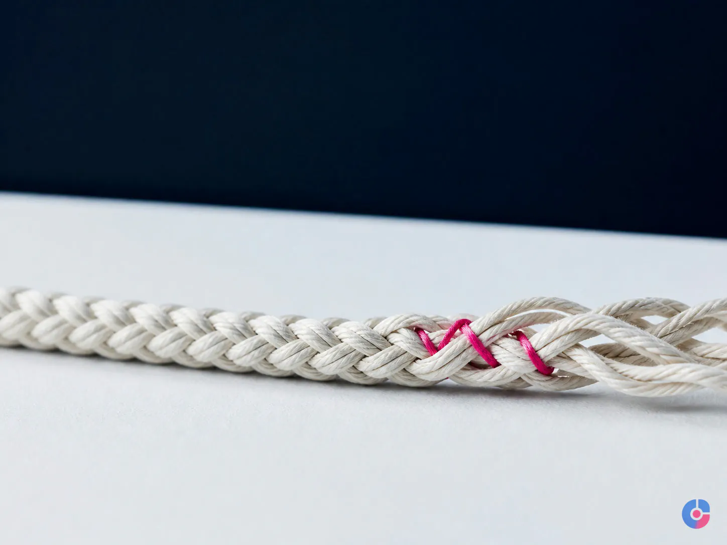 Abstract braided rope with one reinforced section representing customer retention under strain
