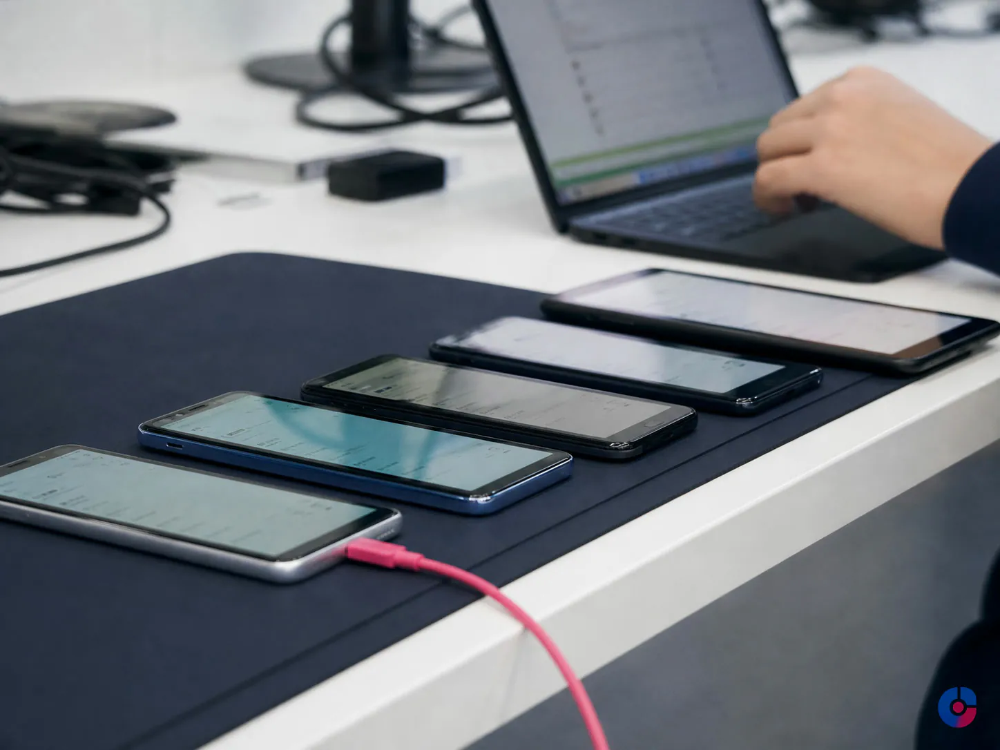 Row of test devices on a bench used for mobile app quality assurance