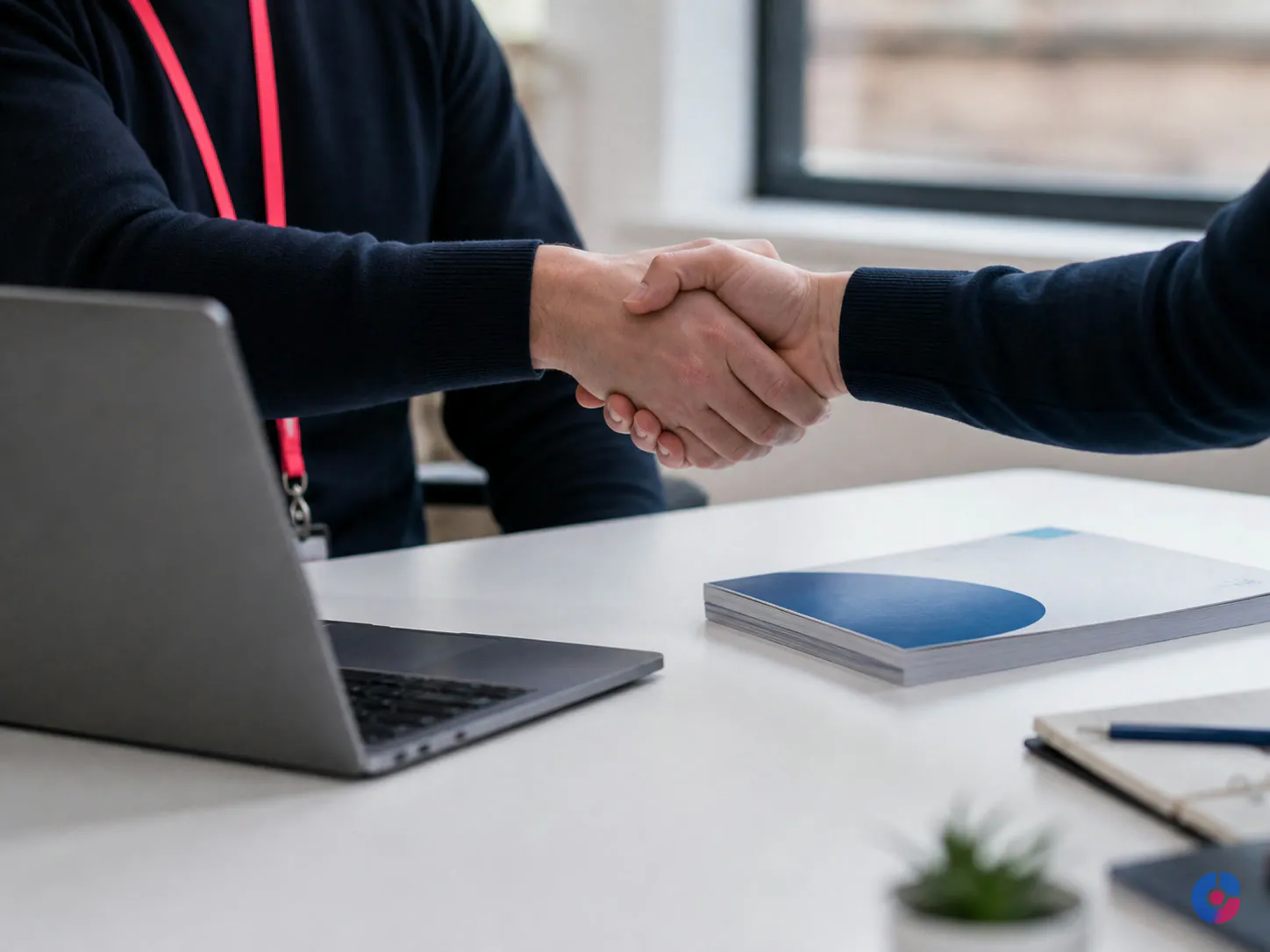 Handshake at the close of an offshore team onboarding session at a desk